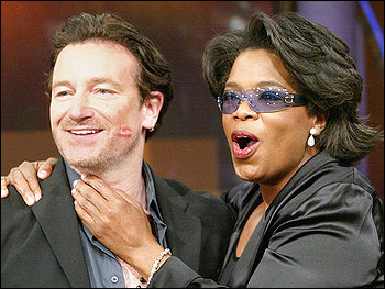 OPRAH THROUGH THE YEARS: Winfrey with Bono after planting a kiss on his cheek in 2002.